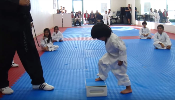 Three-year-old attempting to break board